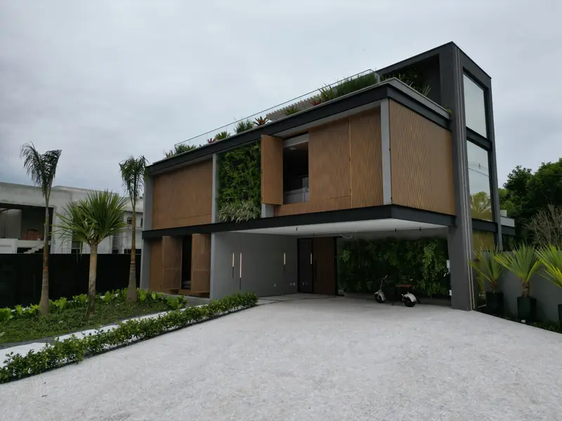 Fachada frontal de casa de alto padrão na Riviera de São Lourenço, Bertioga · AM&D Engenharia